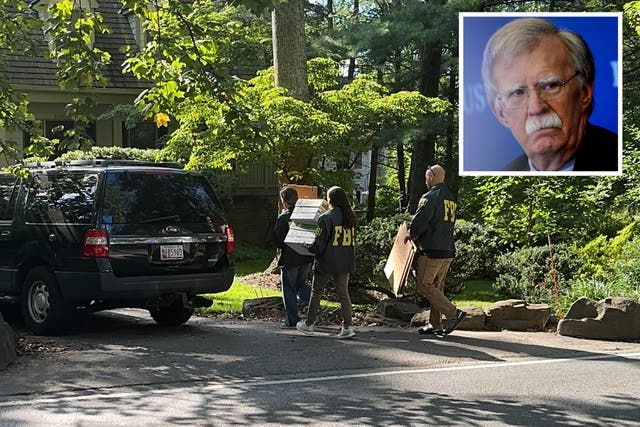 <p>FBI agents are seen outside the home of former national security adviser John Bolton</p>