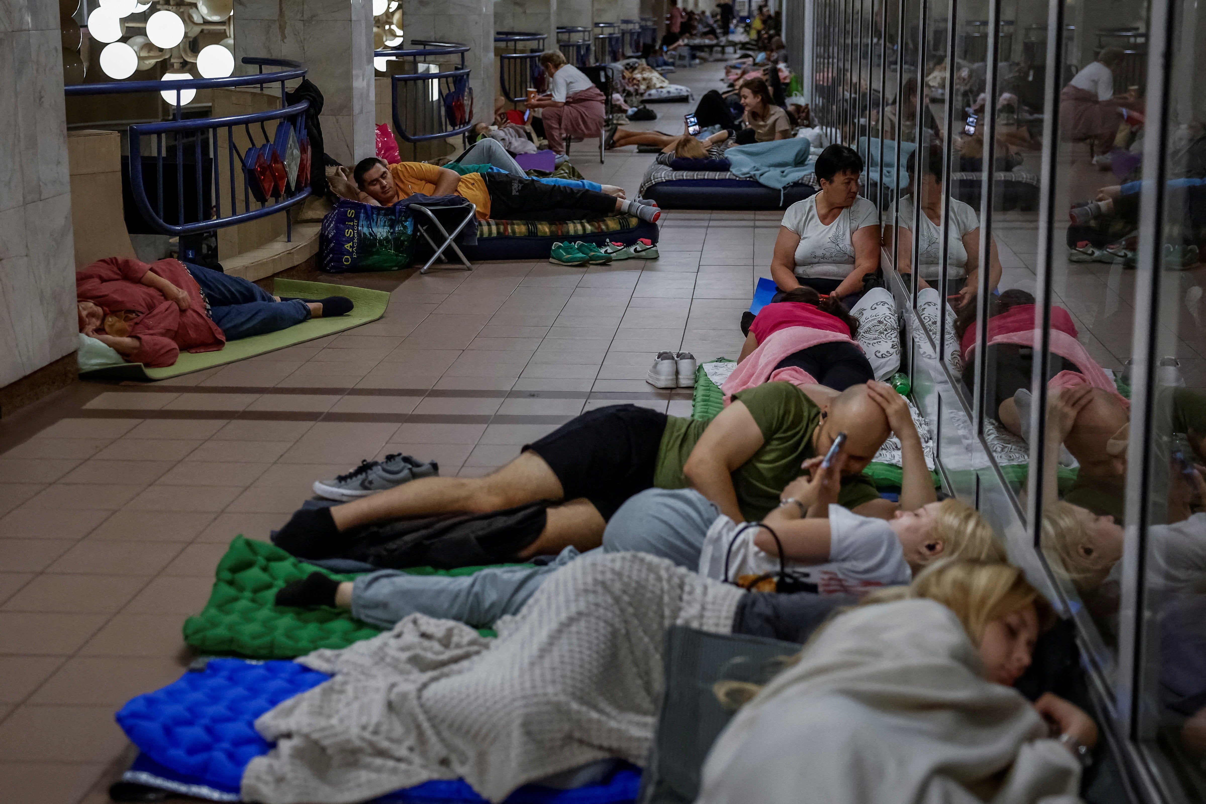 People take shelter inside a metro station during an air raid alert amid Russia's attack on Ukraine