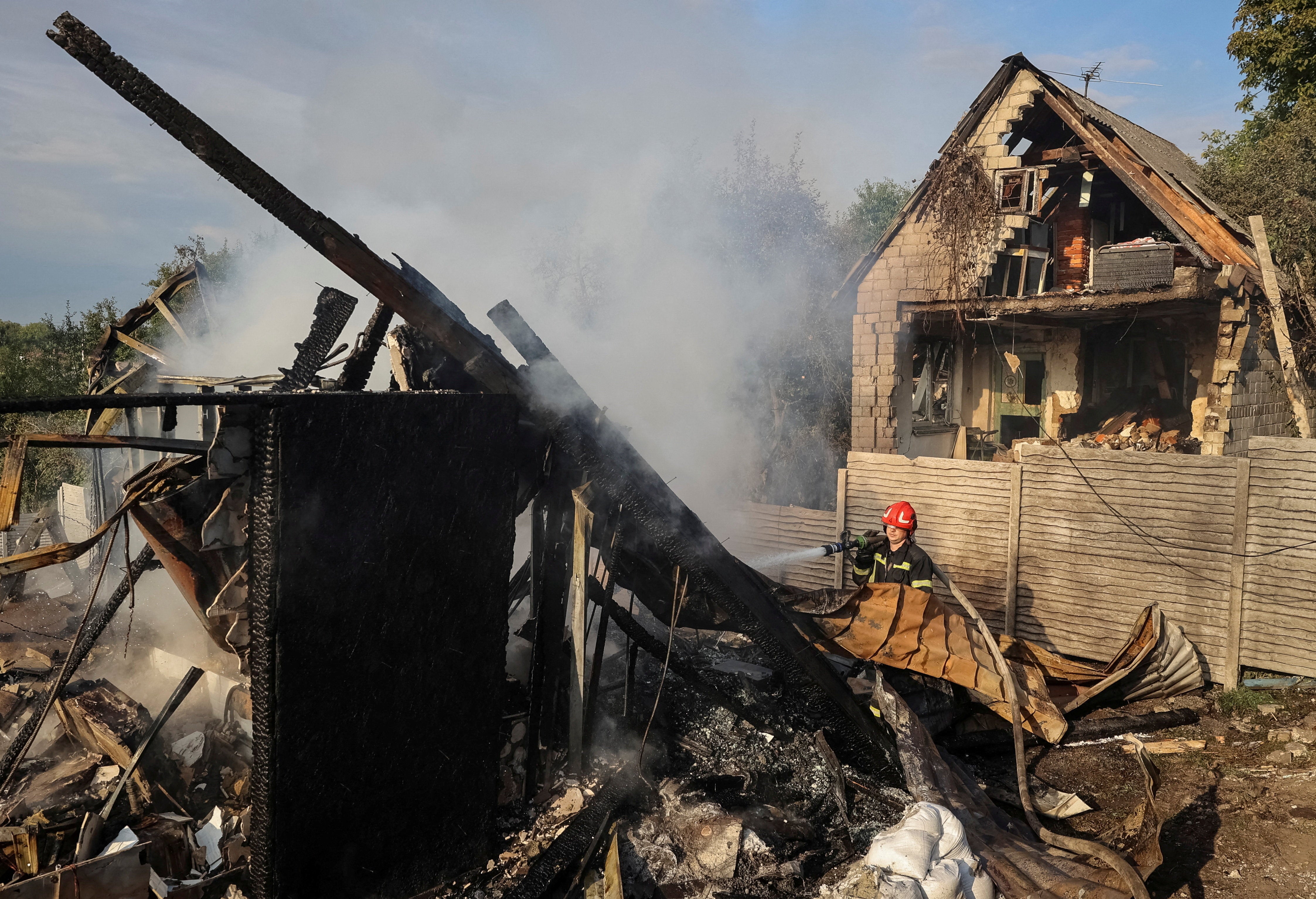 A firefighter works at the site of a Russian missile strike, amid Russia's attack on Ukraine, in the village of Sknyliv on the outskirts of Lviv, Ukraine