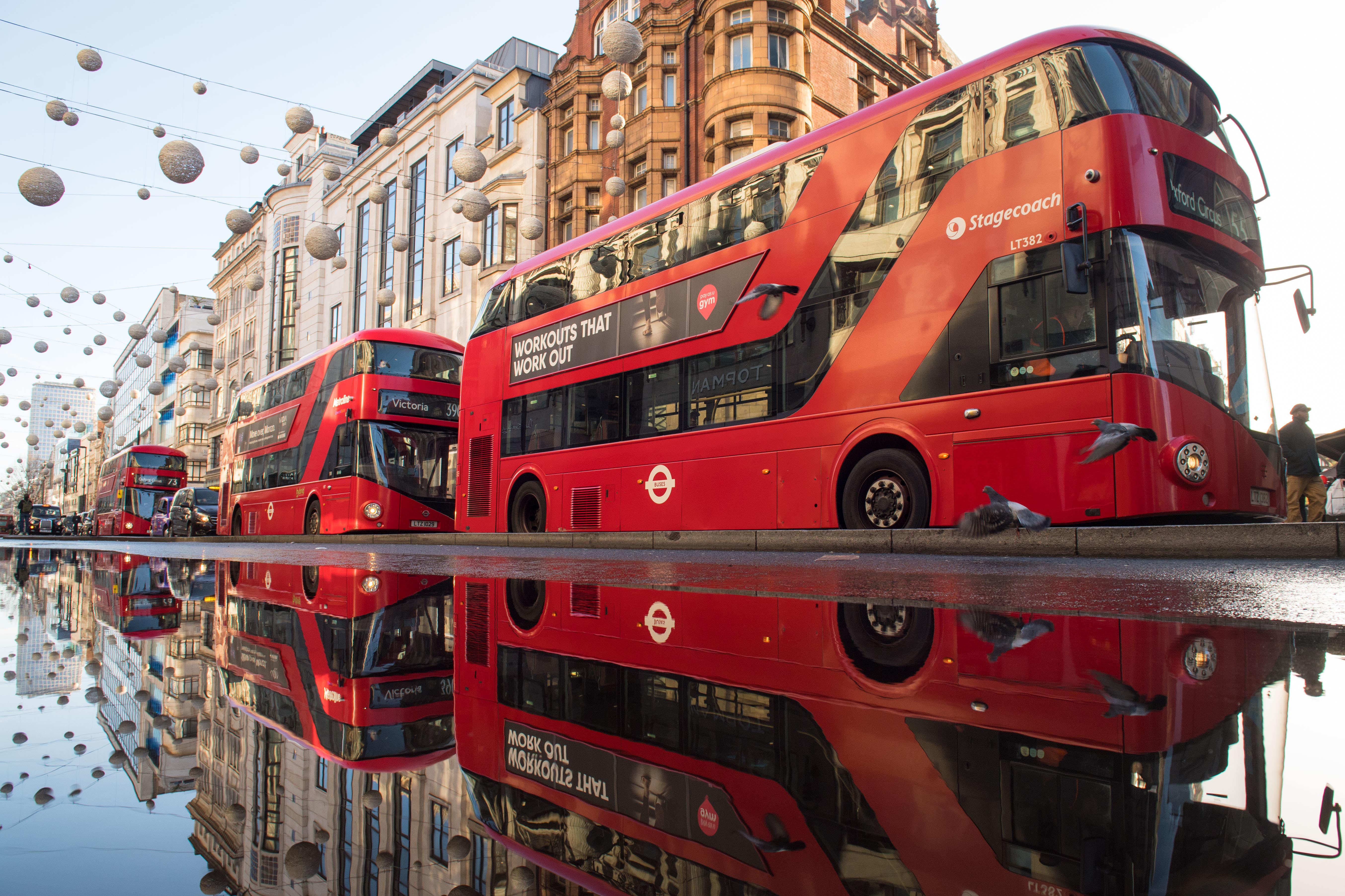 Red London buses are reflected in standing water on Oxford Street, London, following a burst water main in one of the capital’s busiest shopping streets.