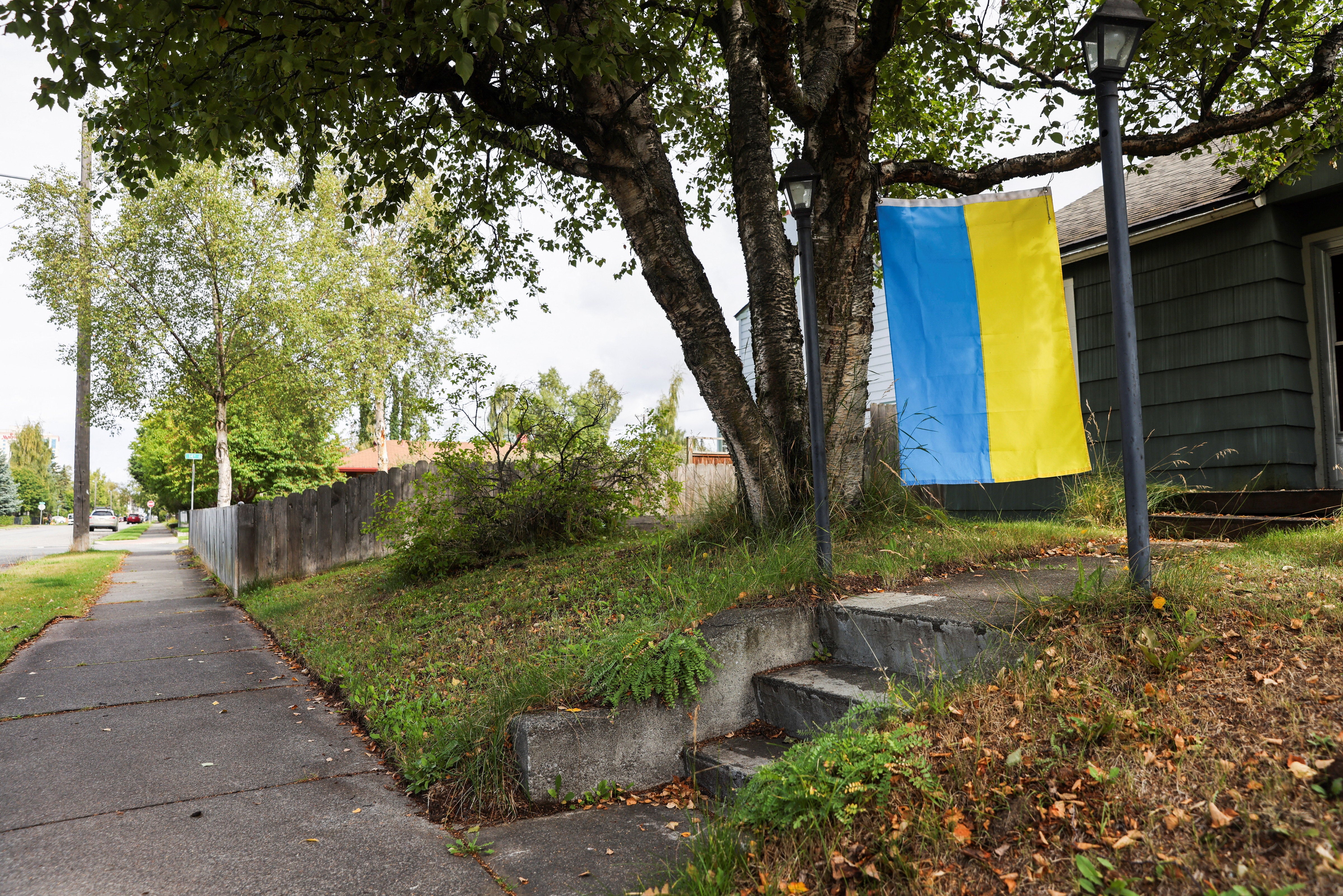 A Ukrainian flag hangs infront of a house
