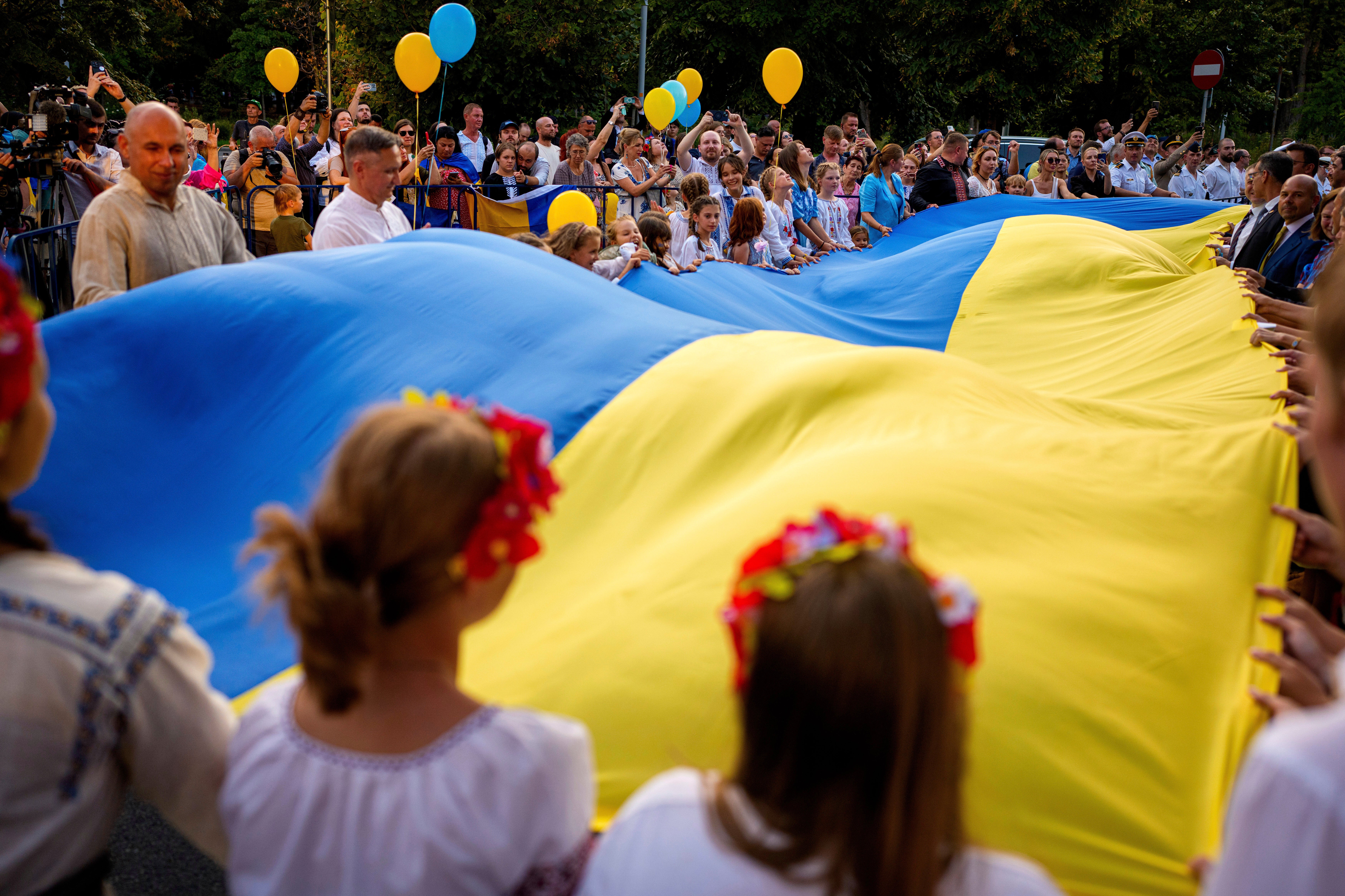 Participants wave a Ukrainian flag during an event of solidarity with Ukraine, marking its upcoming Independence Day