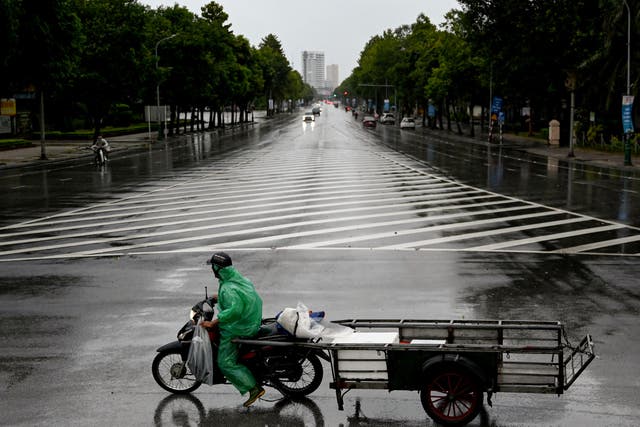 <p>A man rides a motorbike on a road before Typhoon Kajiki makes landfall in Vietnam, in Nghe An province on 25 August 2025</p>