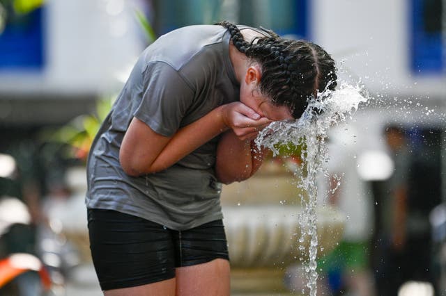 <p>Children play with water fountains in Leicester Square during a heatwave in the UK</p>
