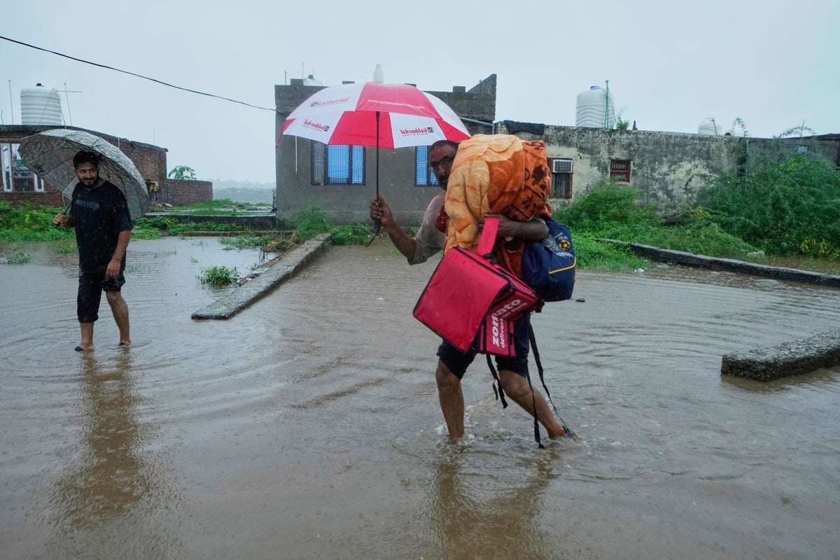 Photos show people fleeing flooding in Kashmir after weeks of intense rain in the region