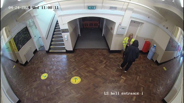 <p>Screen grab taken from Ysgol Dyffryn Aman CCTV footage dated 24/04/24 issued by Dyfed-Powys Police of the 14-year-old girl speaking with teacher Fiona Elias (in a high-vis jacket) before the incident</p>