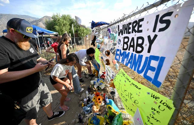 <p>Visitantes se reúnen alrededor de un memorial improvisado antes de una vigilia por Emmanuel Haro</p>