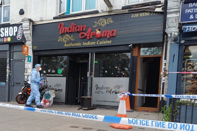 A forensic investigator at a restaurant in Ilford, east London (Helen William/PA)
