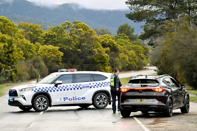 <p>Police divert traffic at a roadblock as they search for a fugitive linked to the murder of two police officers in Porepunkah, Victoria, on 27 August 2025</p>