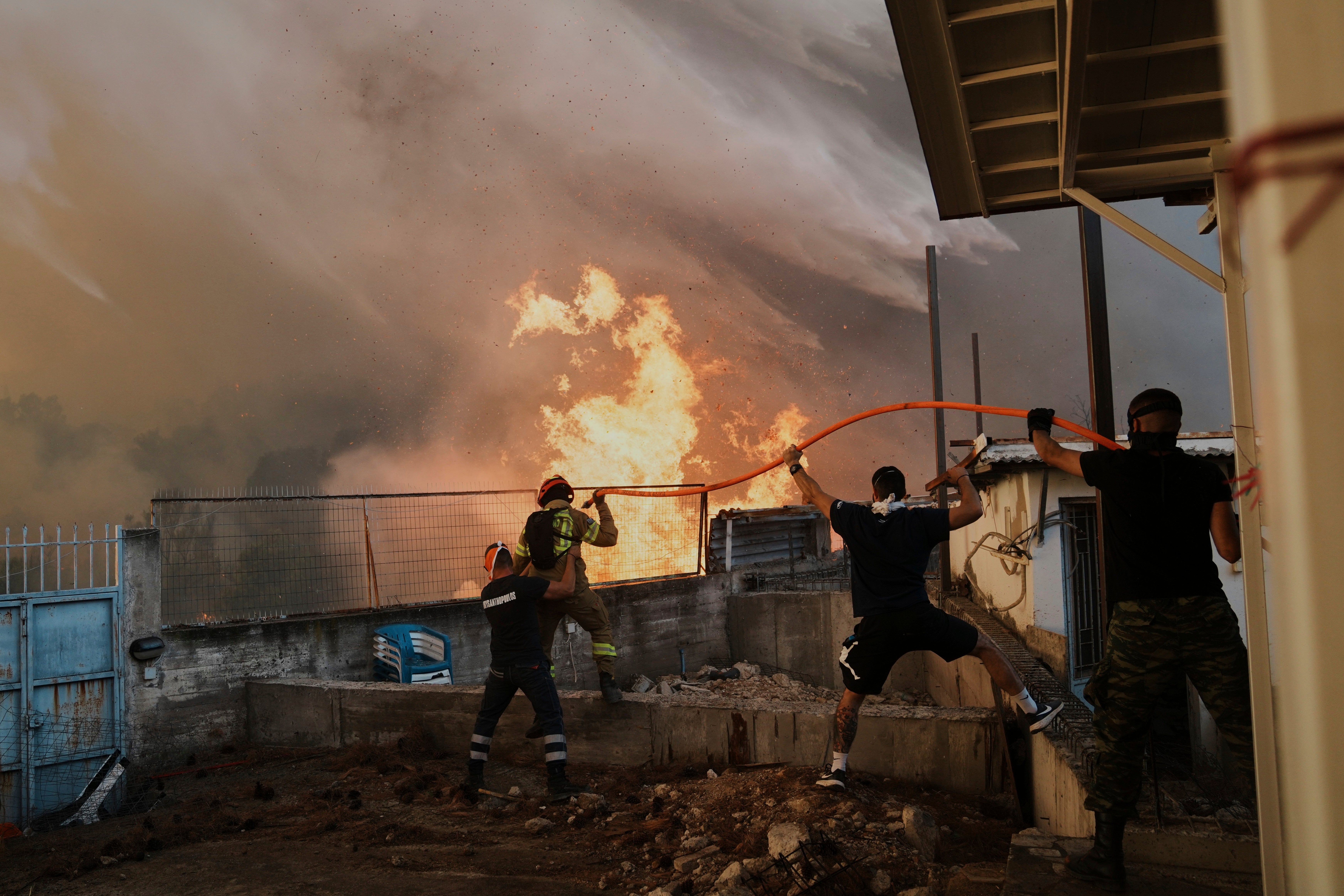 Europe experienced its worst wildfire season on record this year A firefighter and men try to control the flames approaching a house during a wildfire in Patras city