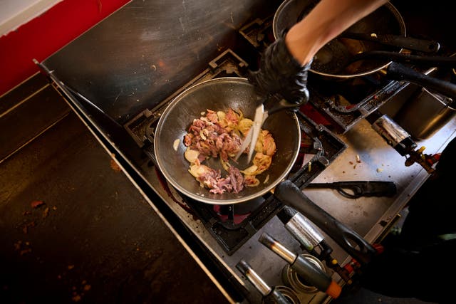 <p>A person cooks inside the Stejk Street Food truck in Kiruna</p>