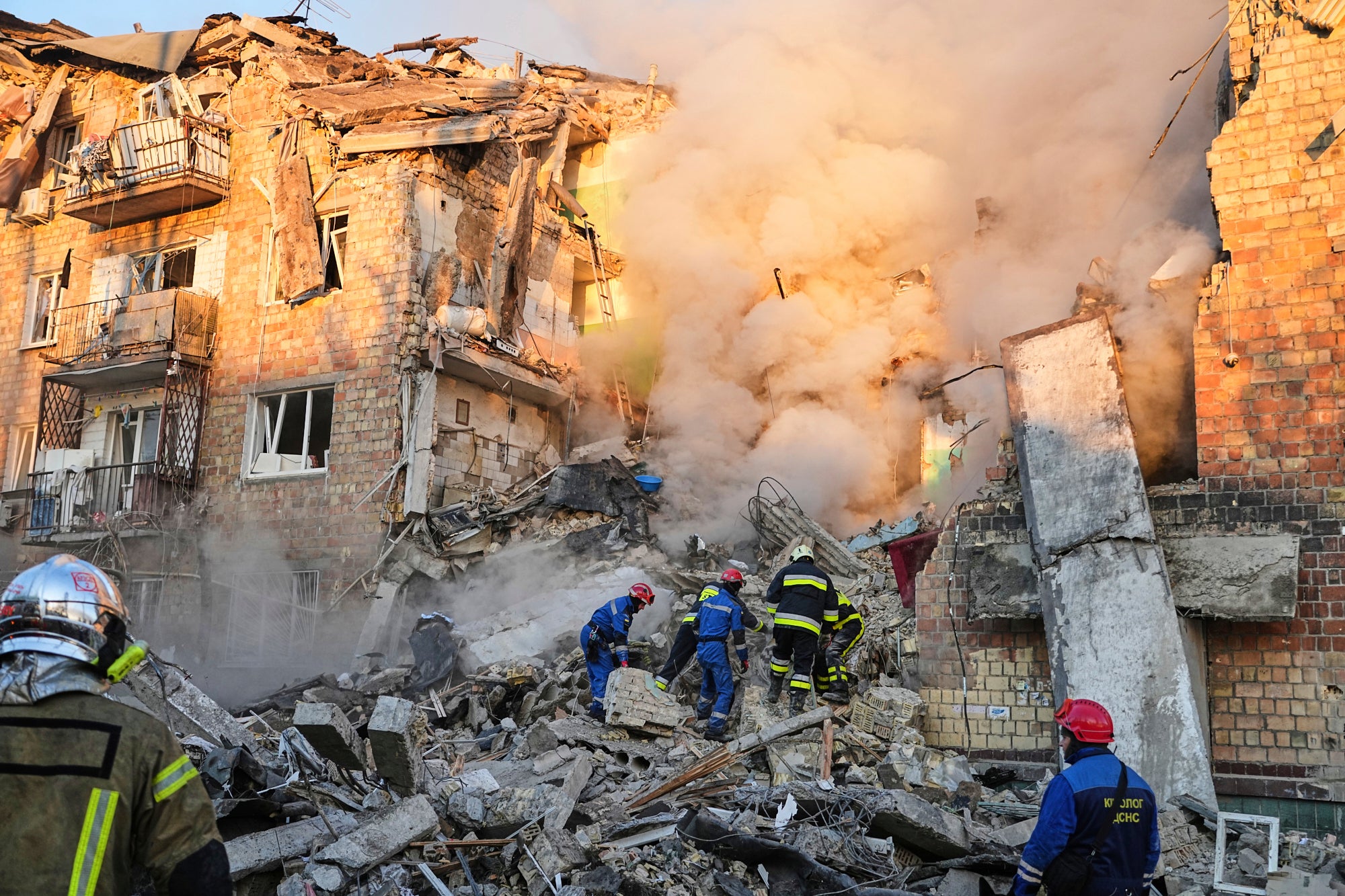 Rescue crews work on the site of a burning building after a Russian attack on Kyiv