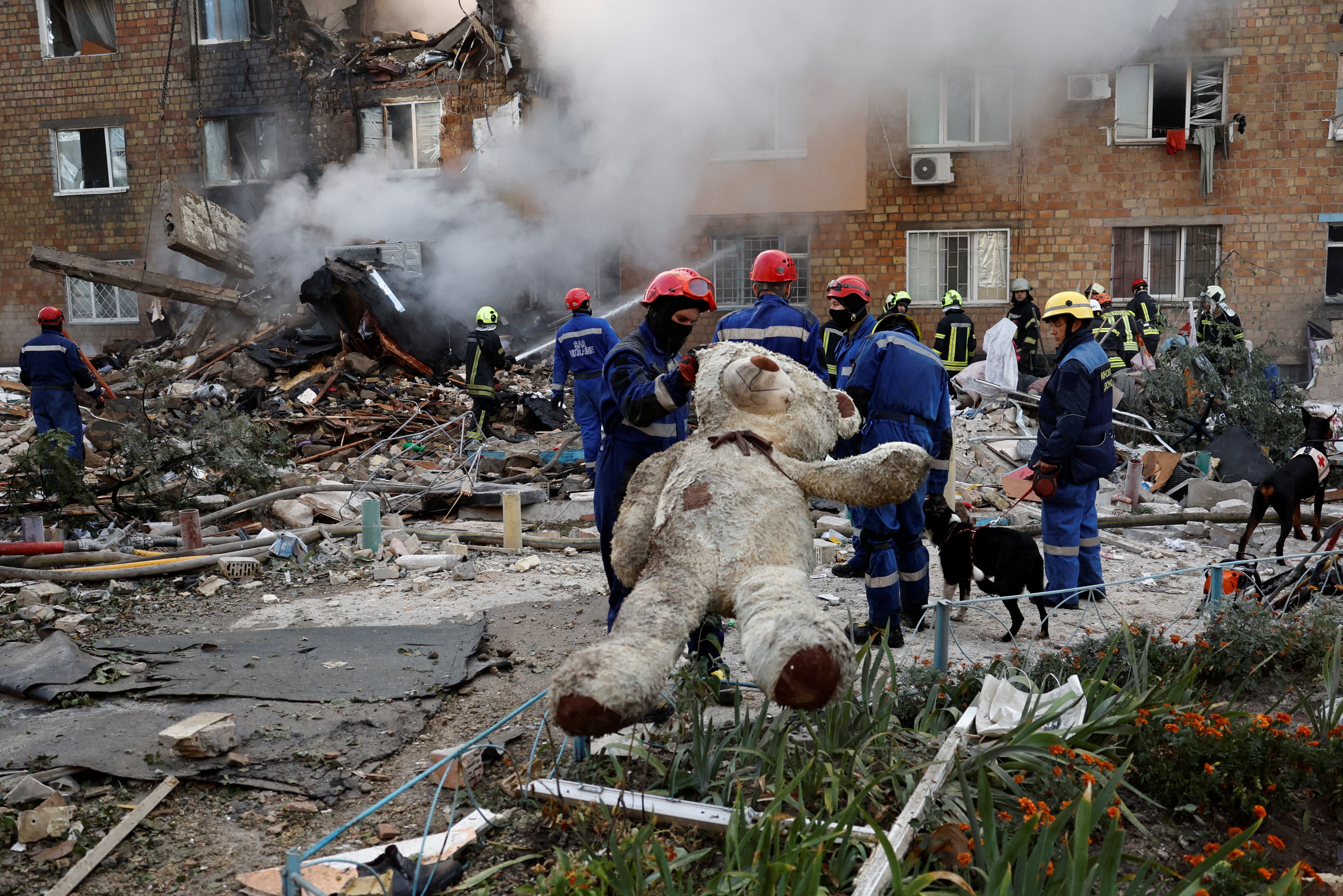 A rescuer holds a soft toy at the site of an apartment building which was hit by a Russian missile and drone strikes
