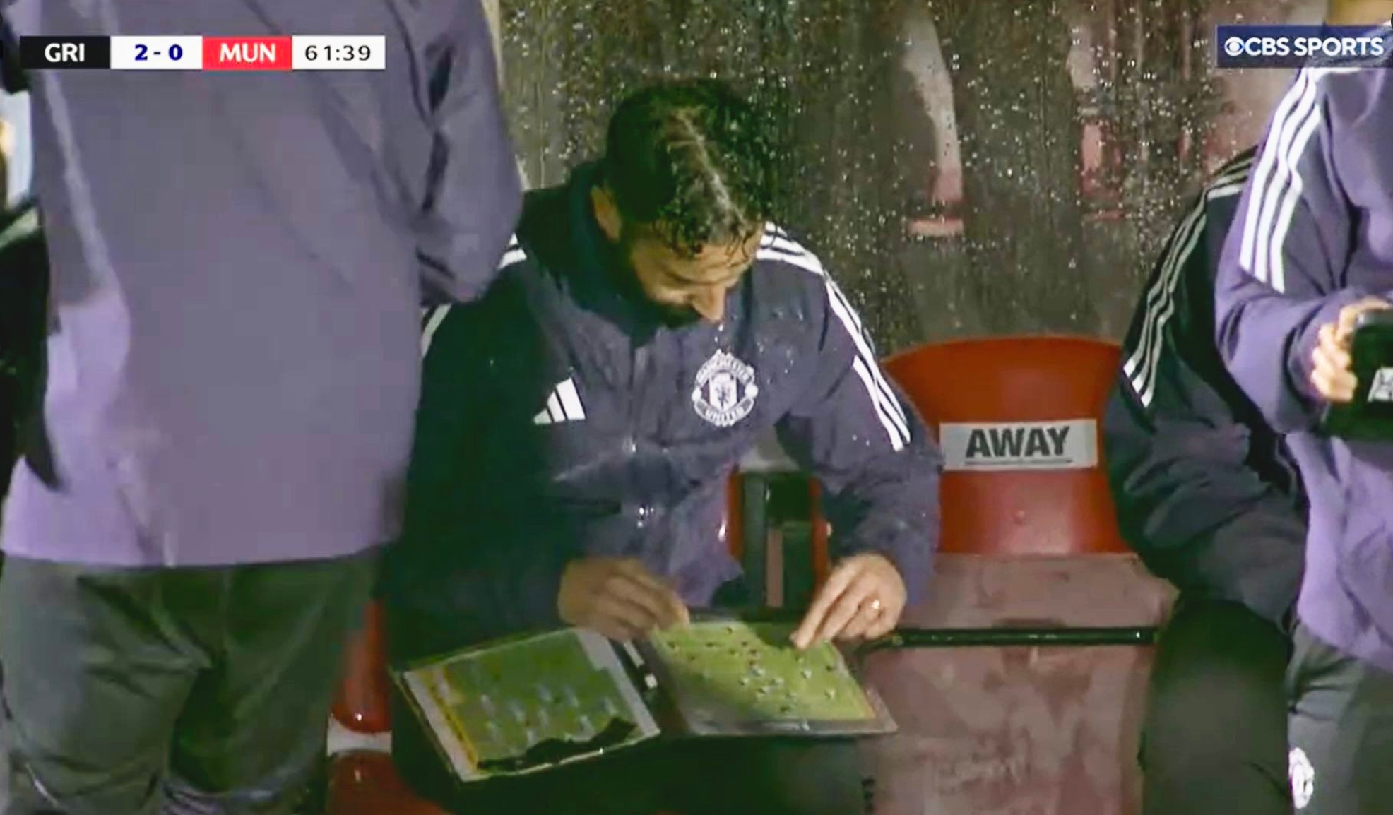 Ruben Amorim consults his tactics board in the dugout during Man United's Carabao Cup second-round tie with Grimsby
