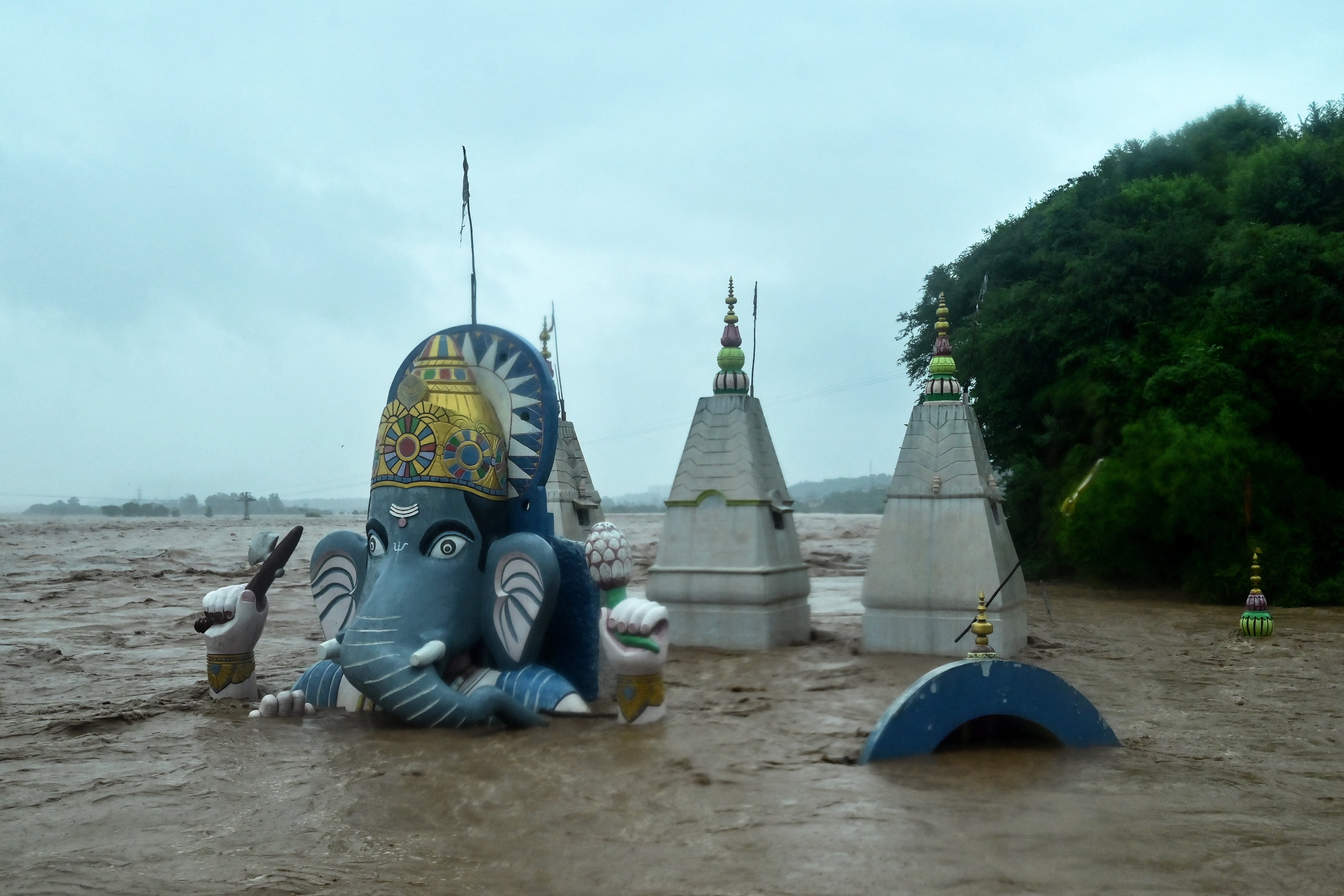 A Hindu temple lies partially submerged in floodwaters after heavy rain induced a rise in the water level of Tawi river in Jammu