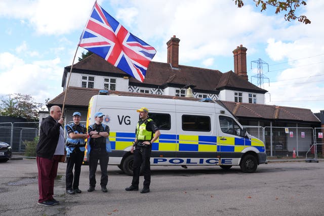 Police officers and protesters outside the Bell Hotel after a temporary injunction that would have blocked asylum seekers from being housed at the hotel in Epping, Essex, was overturned (PA)