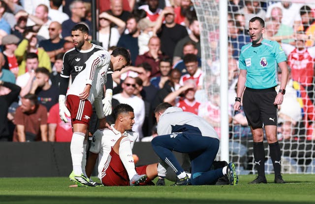 <p>William Saliba receives treatment on the pitch at Anfield</p>