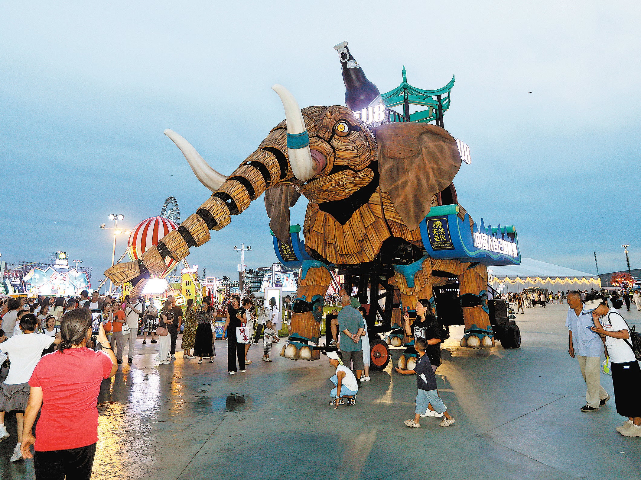 <p>People watch and take pictures of a mechanical elephant during the 23rd Harbin International Beer Festival in Harbin, Heilongjiang province, on 9 August</p>