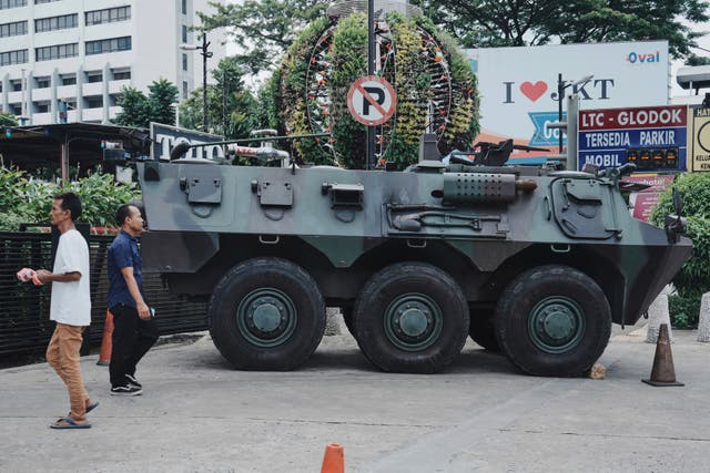 <p>People walk past an army armoured vehicle parked outside a shopping centre following days of violent protests against lawmakers' perks and privileges, in Jakarta, Indonesia, Monday, 1 September 2025</p>