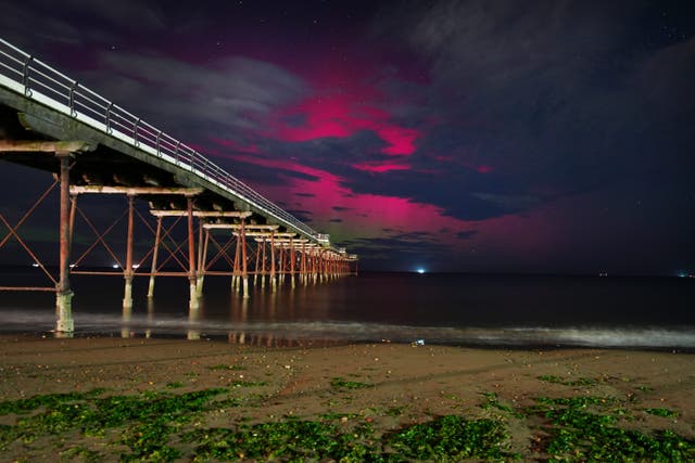 The Northern Lights visible through clouds over Saltburn-by-the-Sea in North Yorkshire on Tuesday morning (Owen Humphreys/PA)