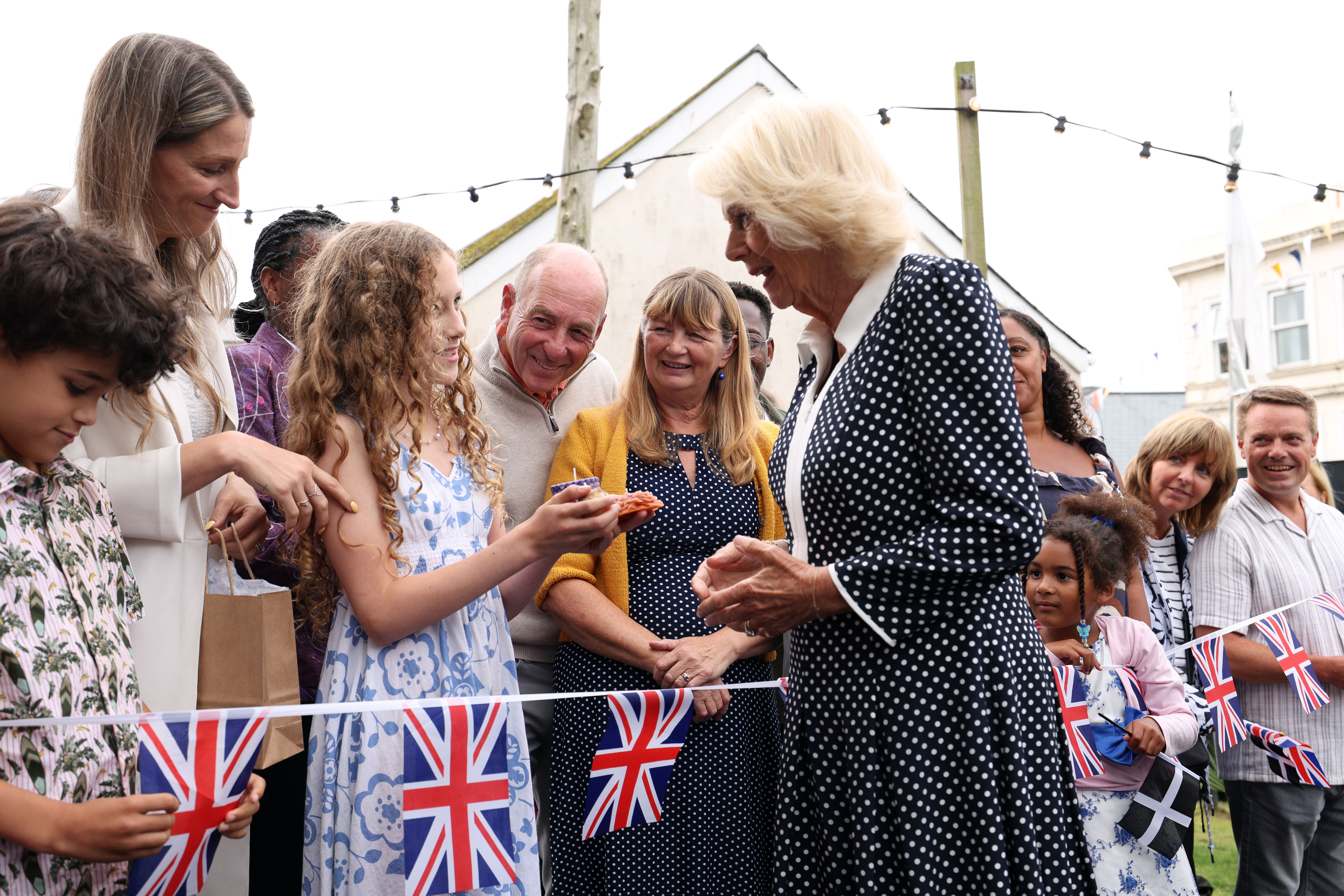 Eliana Grace Daka, aged 11, shows Camilla a homemade candle from her business, during the royal visit to Newquay (Adrian Dennis/PA)