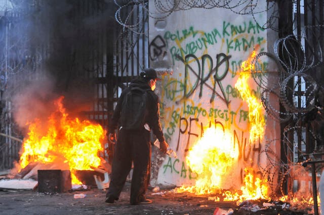 <p>A protester sets fire to the gate of the regional parliament building during a protest against the government's spending priorities, such as enhanced perks for lawmakers, in Bandung, West Java province, Indonesia, 1 September 2025</p>