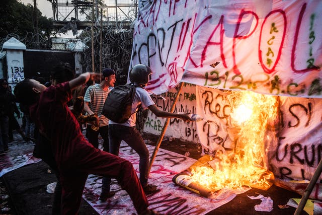 <p>Demonstrators set alight banners as they shout slogans during a protest demanding police reform and the dissolution of the parliament, in Bandung, West Java, on 1 September 2025</p>