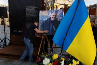 A man sets up a portrait of Andriy Parubiy