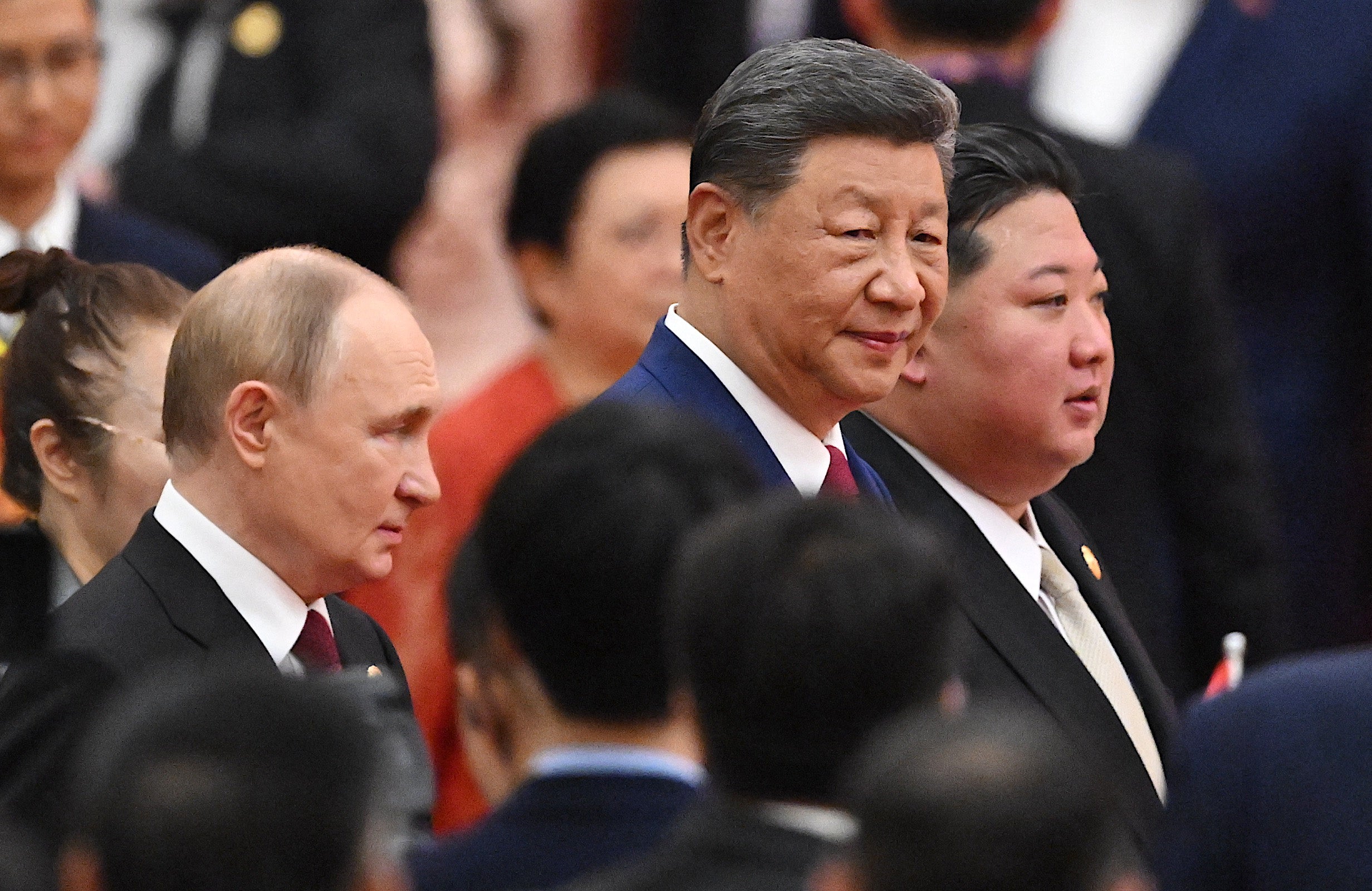 China's president Xi Jinping (C), North Korea's leader Kim Jong Un (R) and Russia's president Vladimir Putin (L) arrive for a reception in the Great Hall of the People