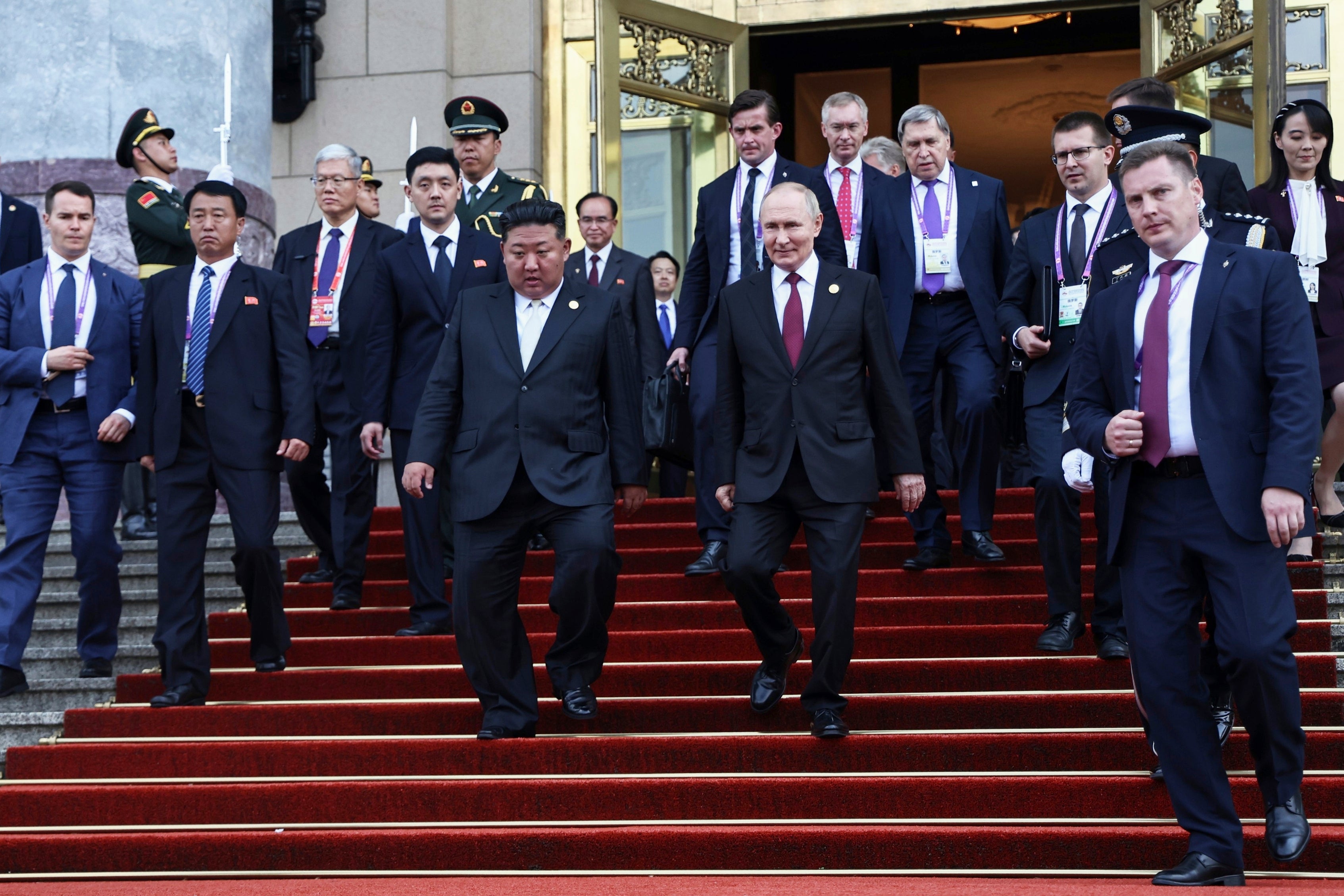Russian president Vladimir Putin, center right, and North Korean leader Kim Jong Un, center left, leave a reception following a military parade