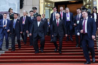 Russian president Vladimir Putin, center right, and North Korean leader Kim Jong Un, center left, leave a reception following a military parade