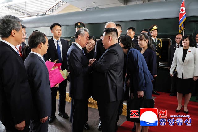 <p>This photograph taken on 2 September 2025 and released by North Korea’s official Korean Central News Agency (KCNA) via KNS shows North Korea’s leader Kim Jong Un (centre R) and his daughter Kim Ju Ae (4th R) being greeted by China’s foreign minister Wang Yi (centre L) upon their arrival at the Beijing Railway Station in Beijing</p>