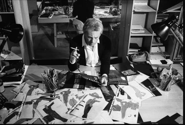 <p>Smoking hot: Giorgio Armani in his atelier studying his iconic designs</p>
