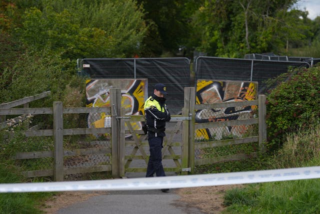 <p>Gardai on an area of open ground in Donabate, Co Dublin during a search for a boy who has not been seen for several years (Niall Carson/PA)</p>