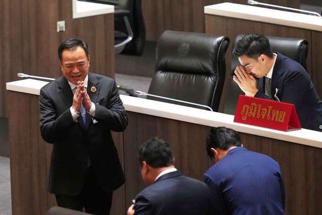 <p>Leader of Bhumjai Thai Party Anutin Charnvirakul, left, talks to lawmakers at Parliament in Bangkok</p>