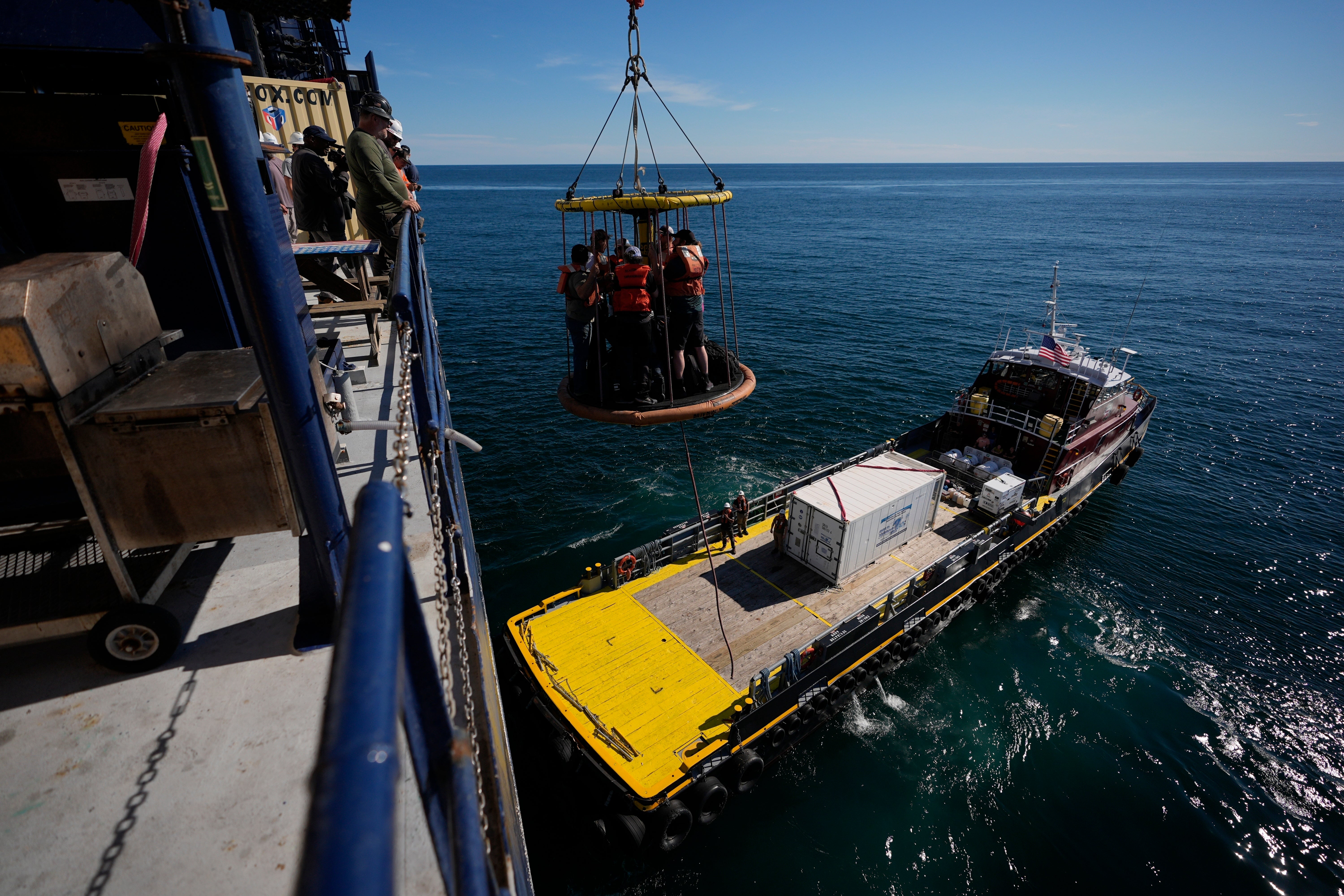 Expedition 501 members in a Billy Pugh basket are lowered from the Liftboat Robert platform to the Gaspee, a crew transport vessel, in the North Atlantic, Saturday, July 19, 2025. (AP Photo/Carolyn Kaster)