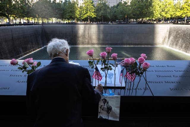 <p>Hagi Abucar places flowers for his former coworker Lindsey Herkness on the south reflecting pool during the 9/11 Memorial ceremony</p>