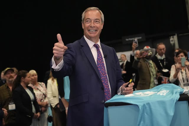 Reform UK leader Nigel Farage signing a football shirt during the party’s annual conference (/PA)