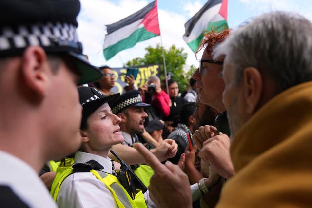 <p>Protesters argue with police officers during a protest last month</p>