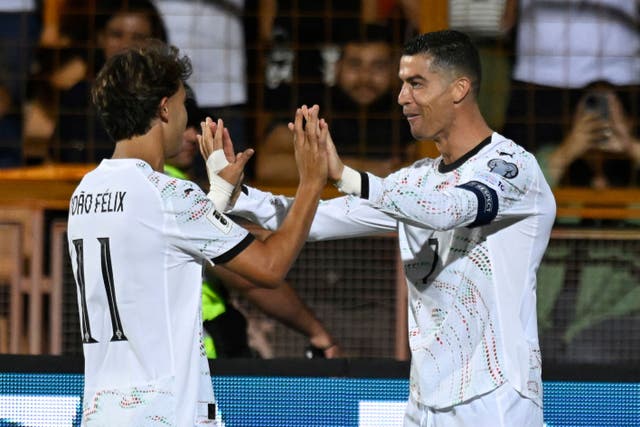 Cristiano Ronaldo, right, celebrates with Joao Felix (Hakob Berberyan/AP)