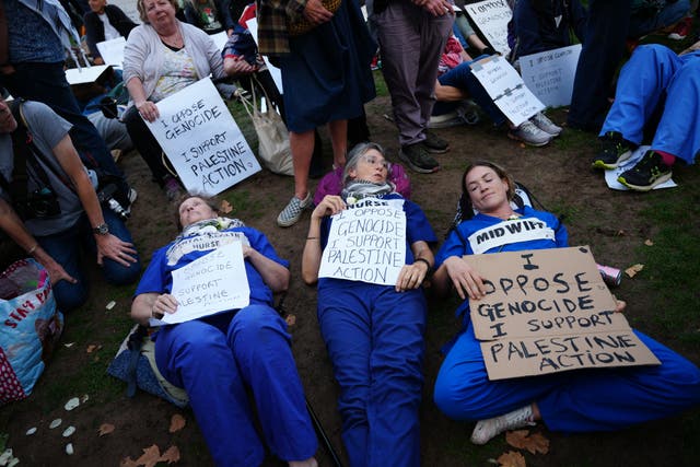 Protesters lying on the ground holding signs in support of Palestine Action during a demonstration (Jeff Moore/PA)
