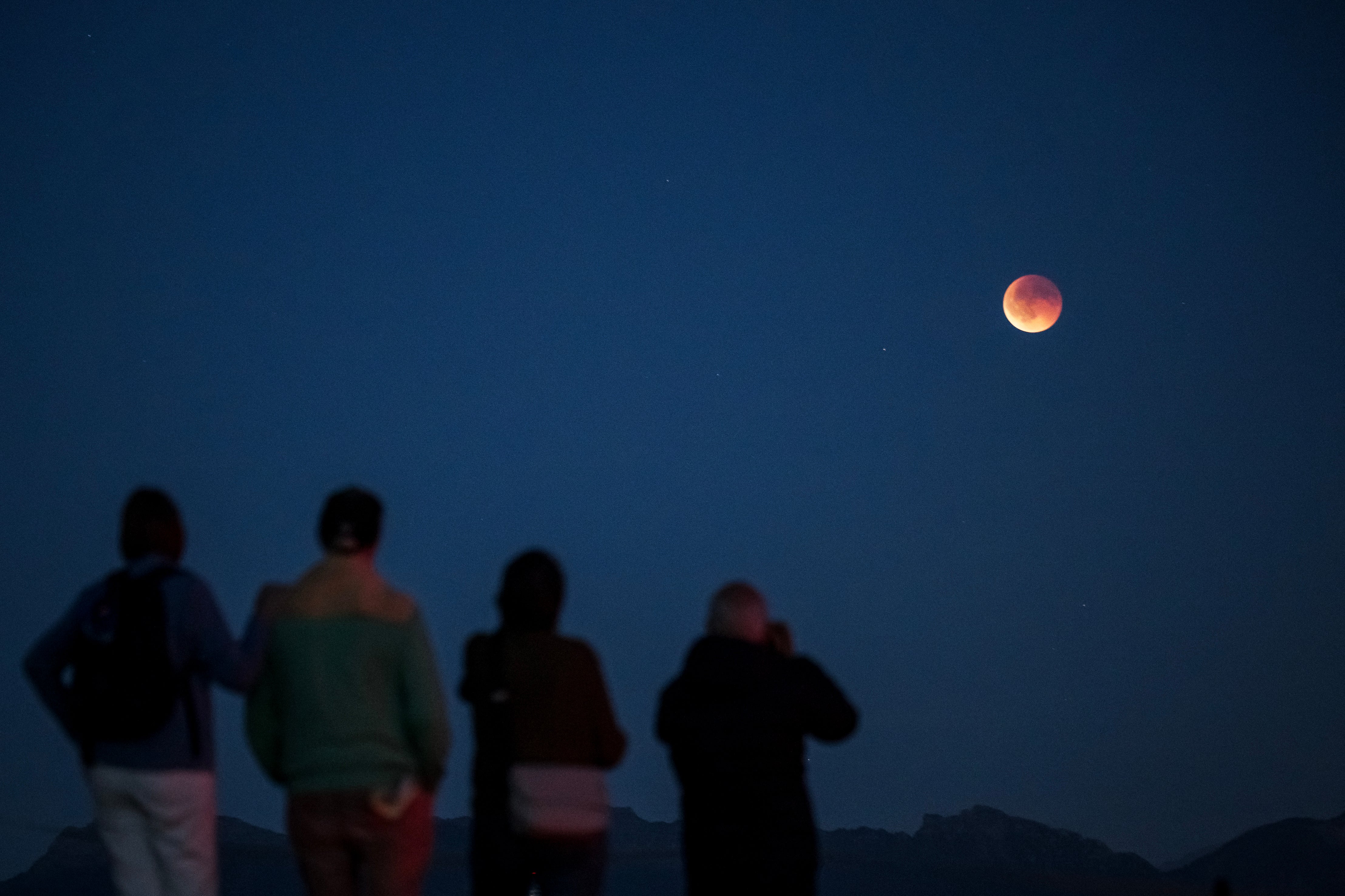 People watch a full ‘Blood Moon’ during a total eclipse from above Riex, western Switzerland