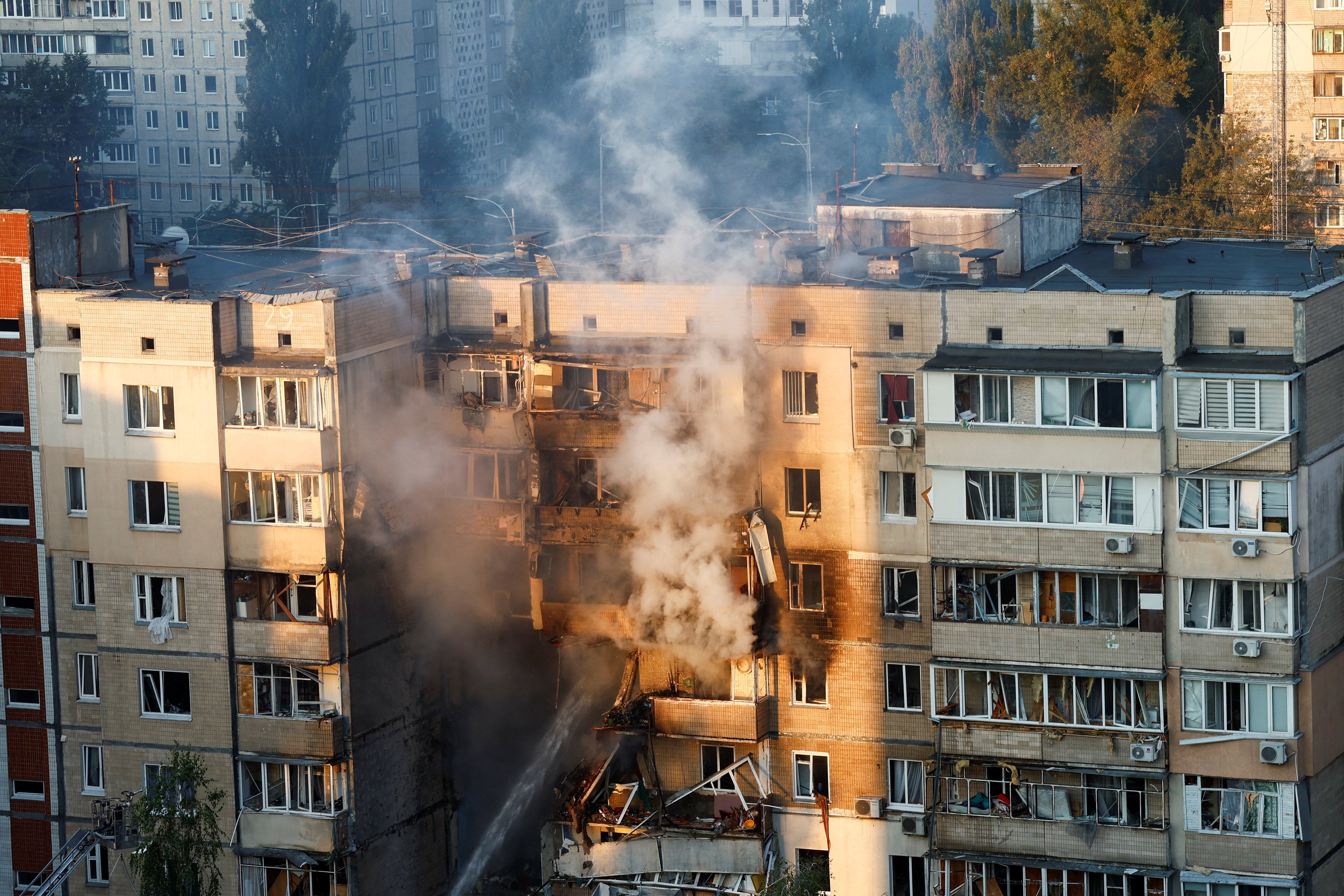 Emergency workers extinguish a fire in an apartment building that was damaged during a Russian drone strike in Kyiv on Sunday 7 September