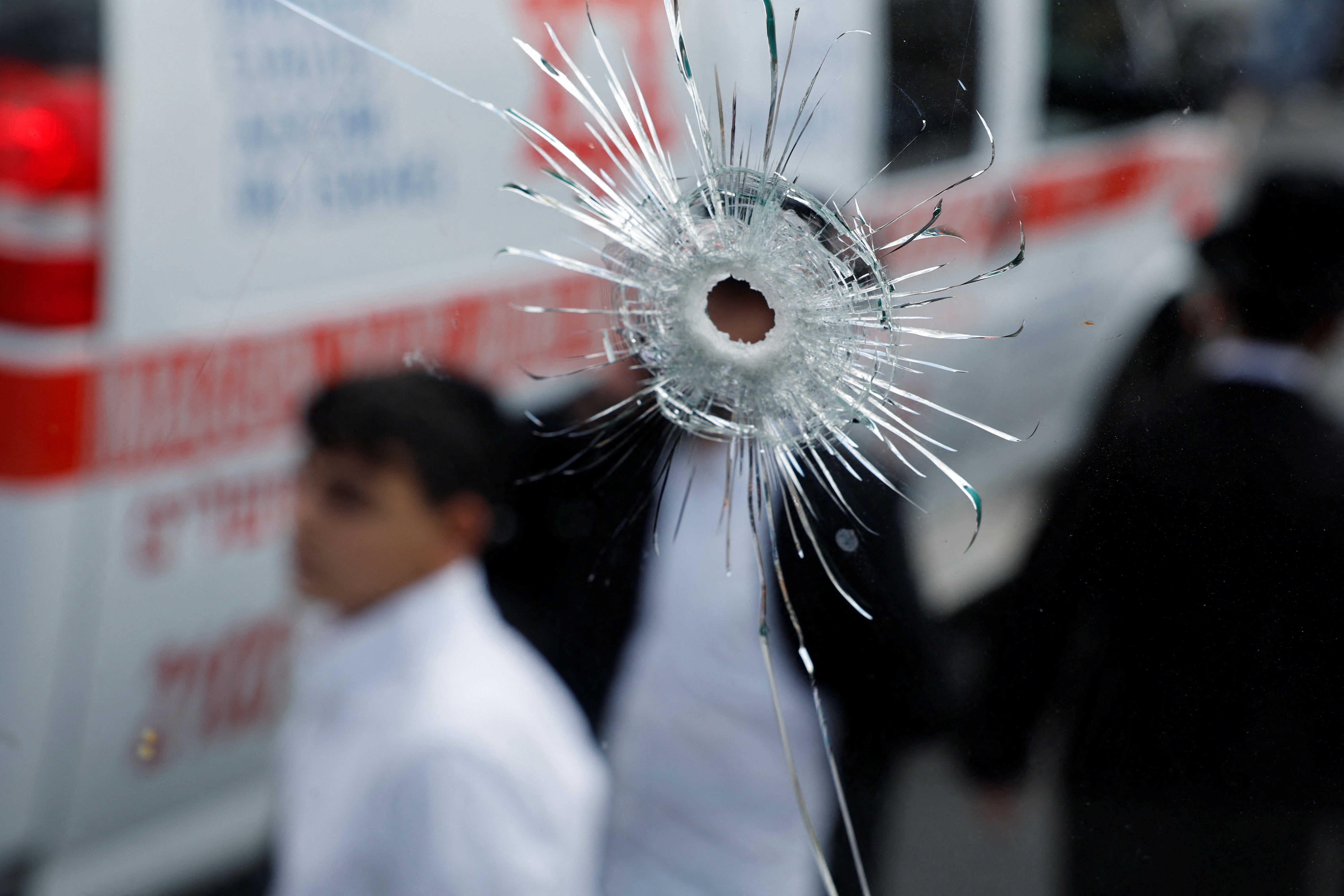 A bullet hole on a bus is seen at the scene where a suspected shooting attack took place