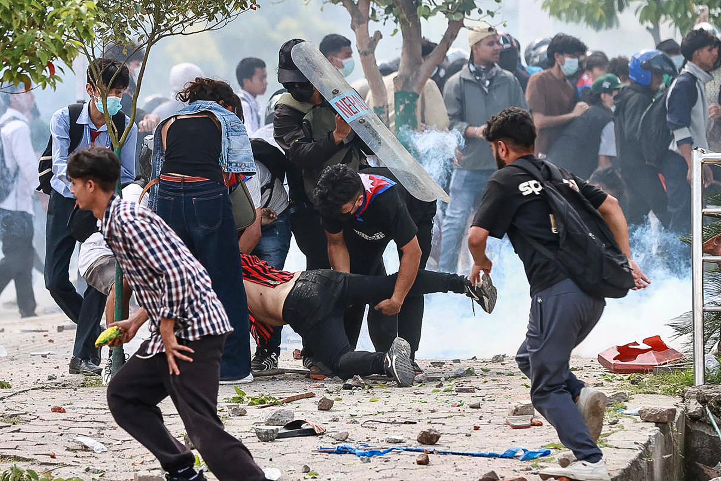 Demonstrators carry an injured victim (C) during a protest outside the Parliament in Kathmandu on 8 September 2025