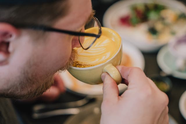 <p>Still shot of a man drinking a golden latte inside a coffee shop in Paris </p>