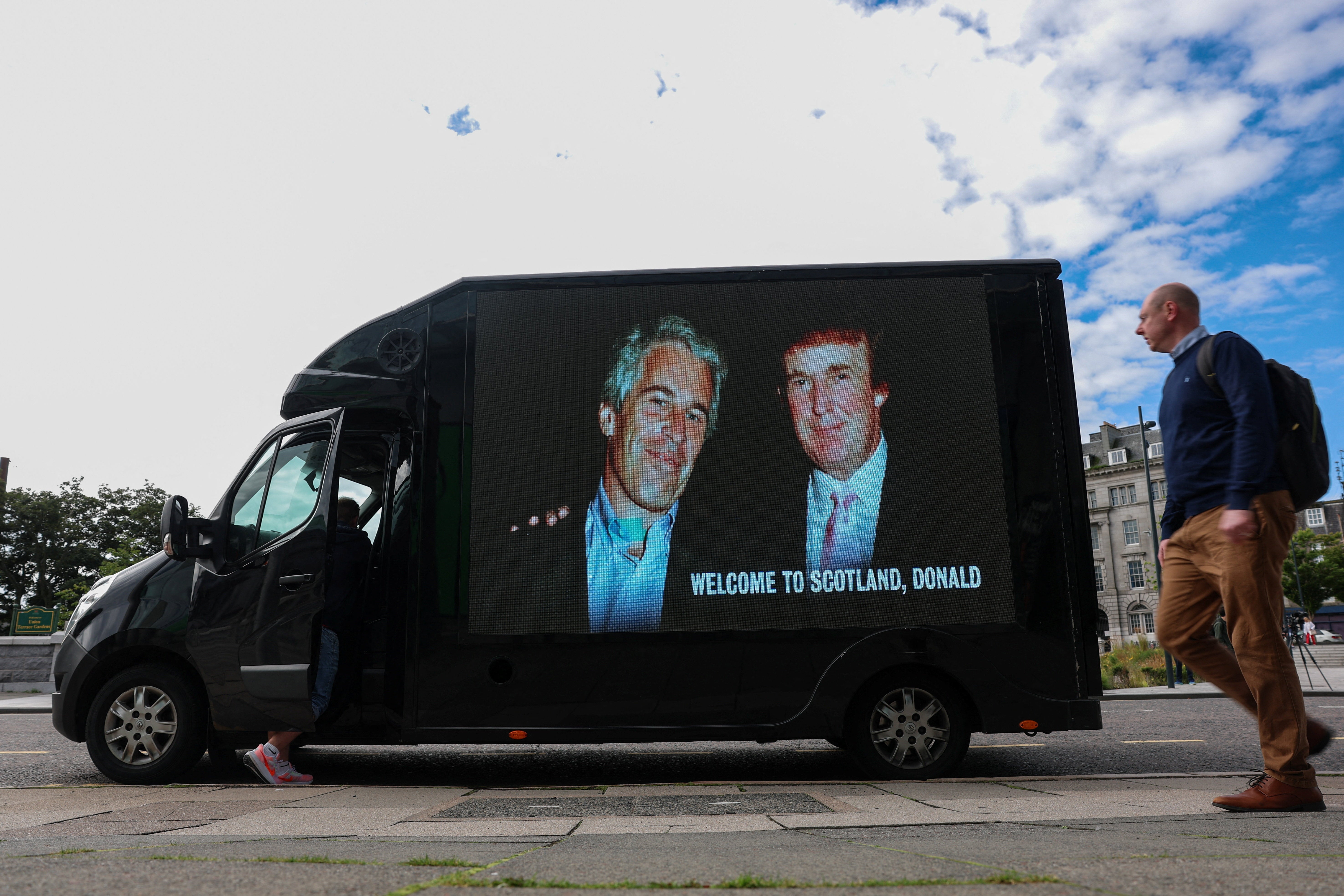Donald Trump and Jeffrey Epstein appear together in a photo on the side of a van. The estate of Epstein has provided an alleged birthday book to the Oversight Committee.