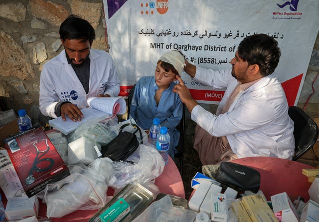 <p>A doctor examines a victim of a deadly magnitude-6 earthquake that struck Afghanistan on Sunday, at a mobile clinic setup inside a school</p>