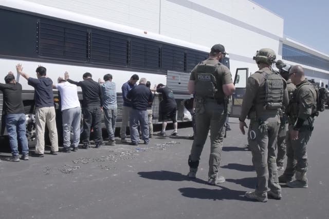 <p>Manufacturing plant employees waiting to have their legs shackled at the Hyundai Motor Group's electric vehicle plant. Hyundai CEO José Muñoz said production at the plant would likely be delayed by months due to the ICE raid</p>