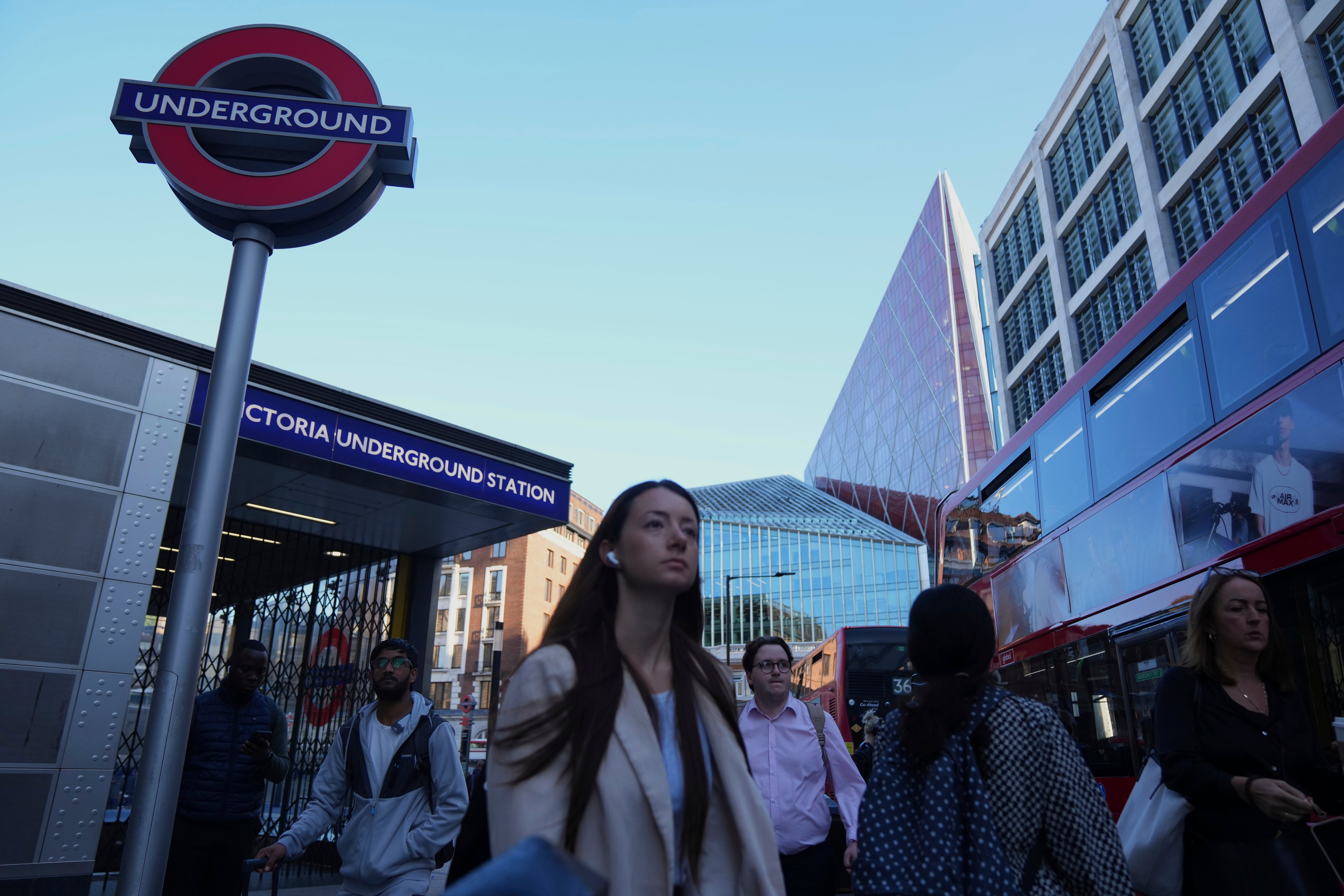 Commuters pass by the closed entrance of Victoria Underground station